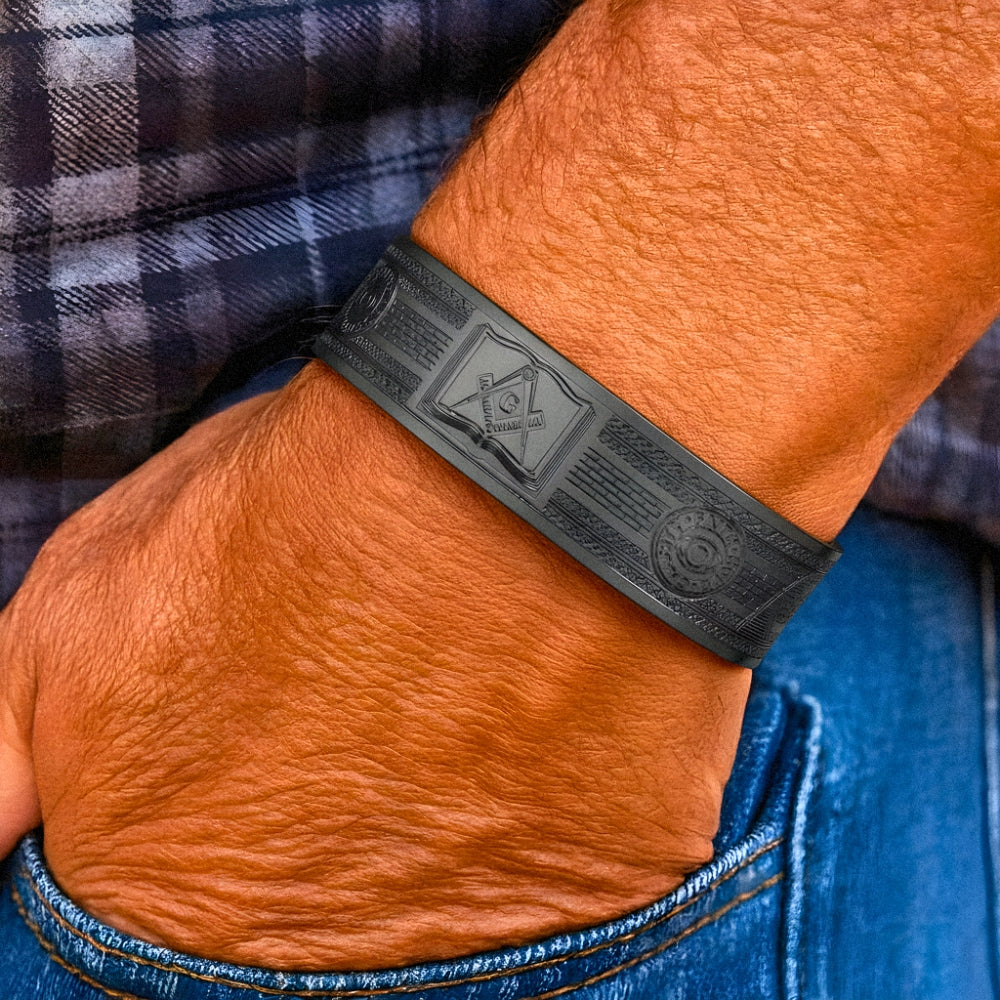 Close-up of engraved Masonic symbols on black copper bangle with magnets inside